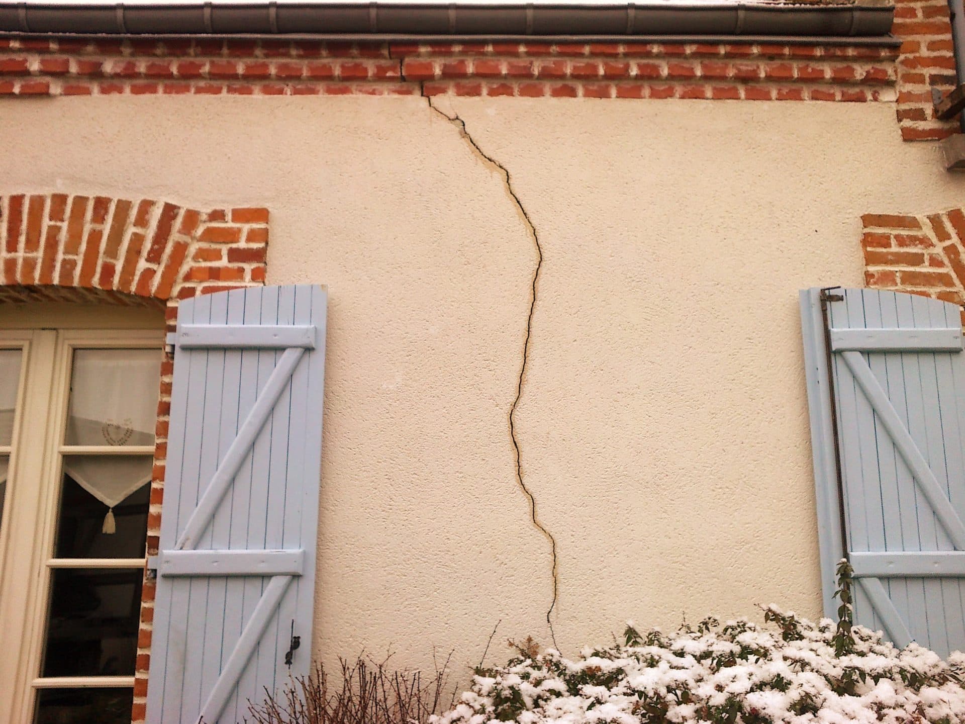 Fissures sur un mur de maison liées au phénomène de retrait-gonflement des argiles